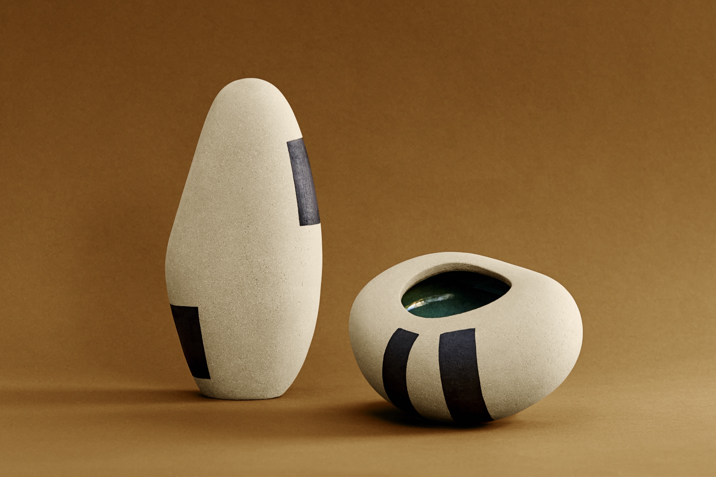 Duo de sculptures Ishi grand format : ovoïde vertical à bandes noires en grès et porcelaine, et Ishi Ouvert en galet révélant un émail turquoise intérieur